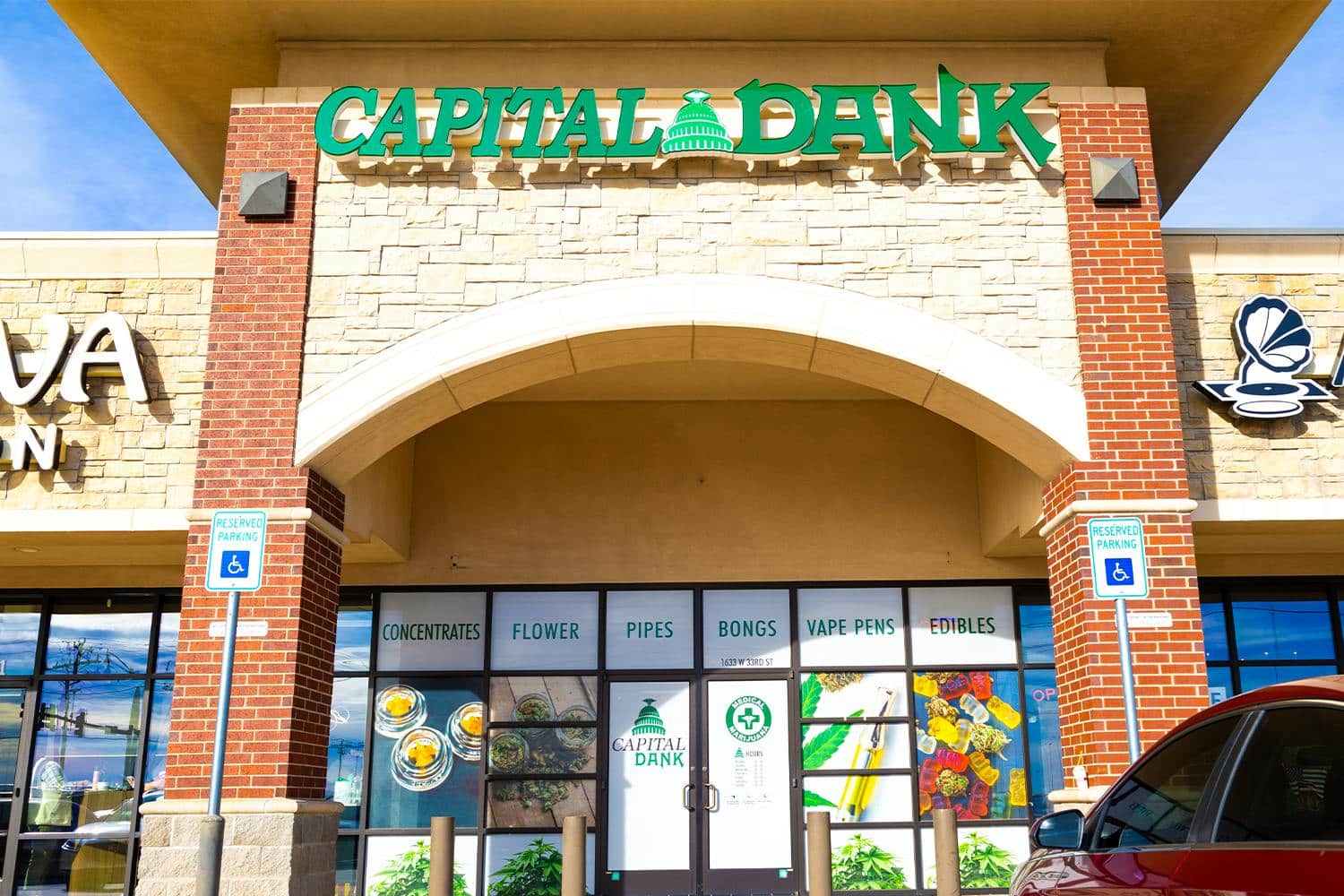 Exterior view of Capital Dank dispensary in Edmond, Oklahoma, featuring storefront signage and product categories like concentrates, flower, pipes, bongs, vape pens, and edibles near 1633 W 33rd St.